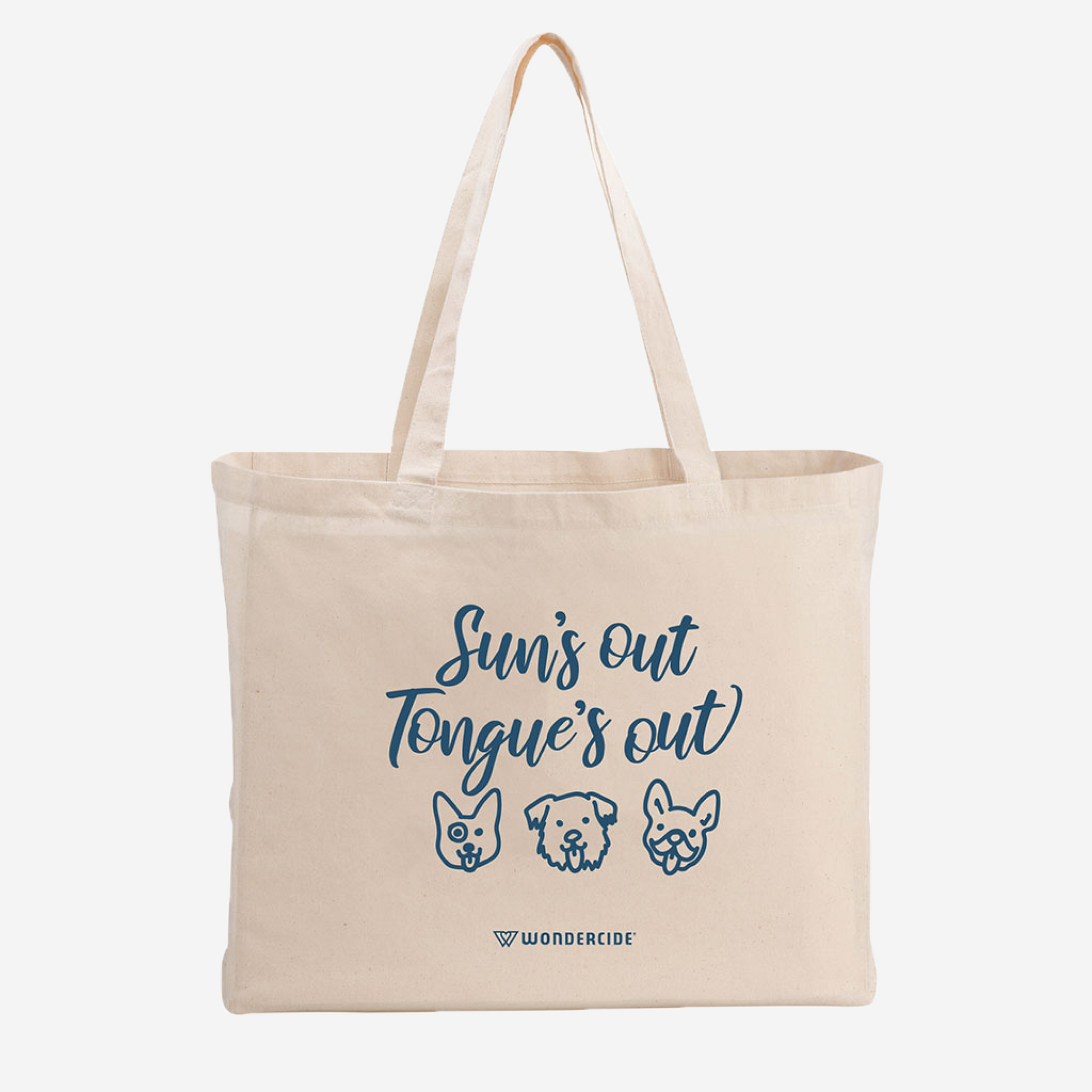 The Suns Out Tongues Out Tote by Wondercide is a stylish beige bag, perfect for trips. It features playful line drawings of three dogs with their tongues out, blue text saying Suns out, Tongues out, and the brand name at the bottom.