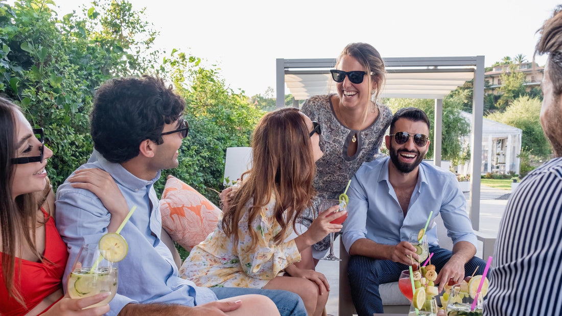 A group of friends enjoys time outside together with drinks