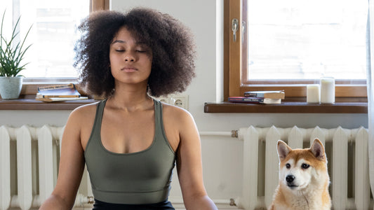 A person in a relaxed yoga pose with a dog