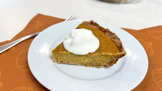 A slice of pumpkin pie with vegan whipped cream on top