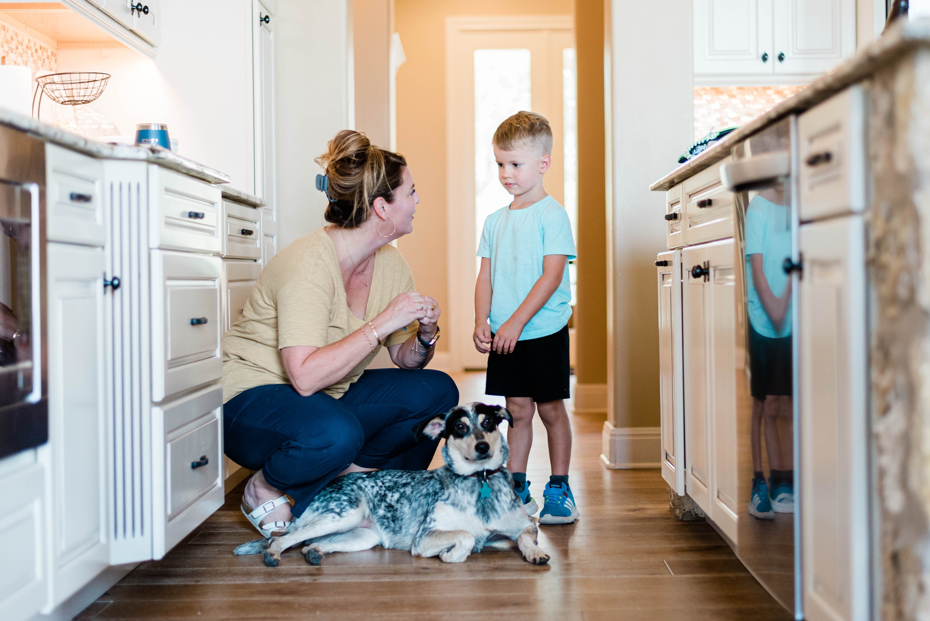 mother in kitchen with son and dog