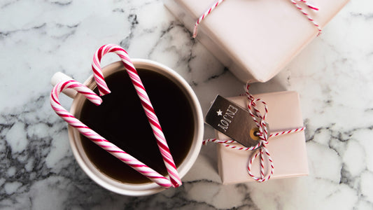 Peppermint candy on a mug surrounded by presents