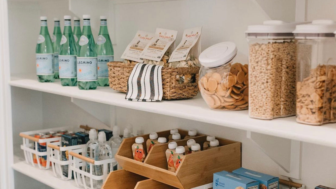 An organized pantry with food on white shelves