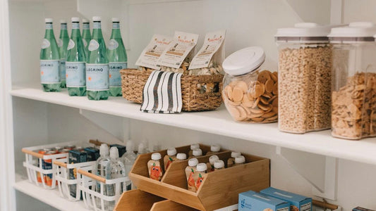 An organized pantry with food on white shelves