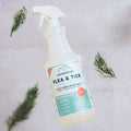 A bottle of Wondercide Cedarwood Flea & Tick Spray for Pets + Home sits on a light surface with pine branches—ideal for naturally protecting your pets and home.