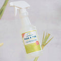 A bottle of Wondercide Apartment Treatment Kit | Flea & Tick Spray, made with natural essential oils and safe for pets, stands upright with lemongrass pieces in the background on a light surface.