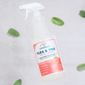 A spray bottle labeled Wondercide Flea & Tick Spray for Pets + Home with a peppermint scent rests on a light surface, surrounded by scattered mint leaves. Safe for use around dogs and cats.