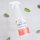 A spray bottle labeled Wondercide Flea & Tick Spray for Pets + Home with a peppermint scent rests on a light surface, surrounded by scattered mint leaves. Safe for use around dogs and cats.