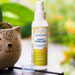 A bottle of Wondercide Lemongrass Insect Repellent for Family with Natural Essential Oils and a white spray cap sits beside a cat-shaped planter, its label emphasizing the fresh lemongrass scent amid softly blurred greenery.