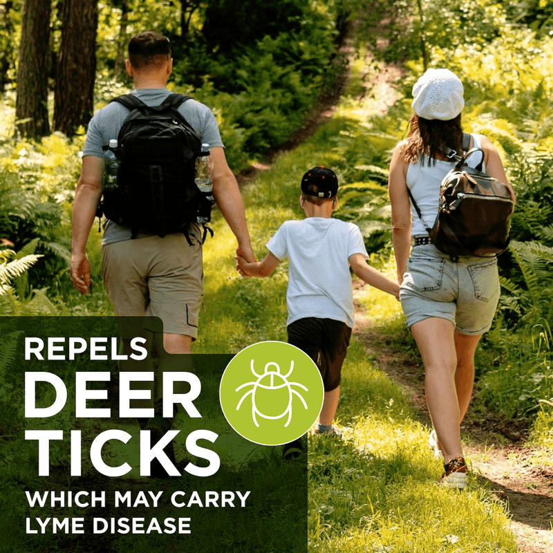 A family of three hiking on a forest path, viewed from behind, with a dark green text banner in the lower left that reads 'REPELS DEER TICKS WHICH MAY CARRY LYME DISEASE' alongside a green tick icon.