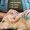 A person uses Wondercide RESCUE™ Ear Drops to gently clean a relaxed golden retriever’s ear, soothing irritation. Text on the image says: No alcohol, No sting, No dyes. Brand: Wondercide.