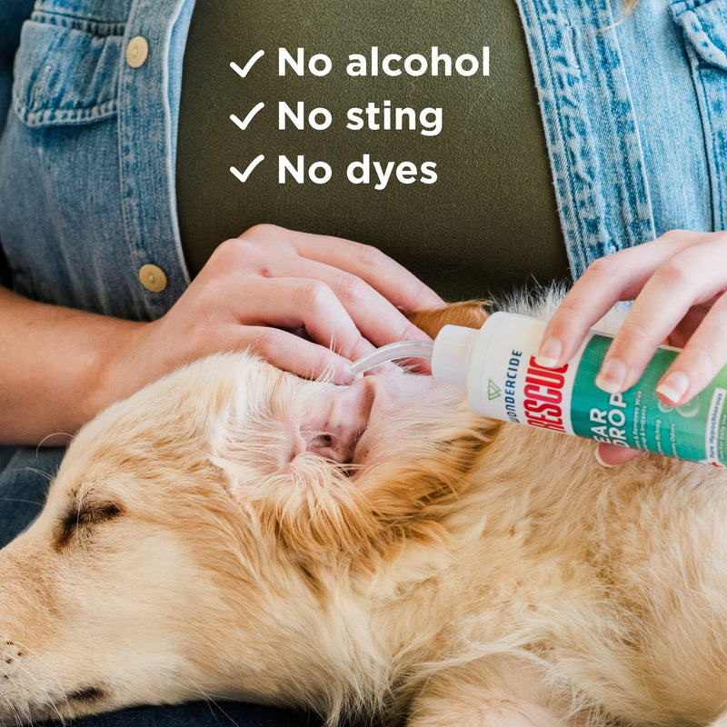 A person uses Wondercide RESCUE™ Ear Drops to gently clean a relaxed golden retriever’s ear, soothing irritation. Text on the image says: No alcohol, No sting, No dyes. Brand: Wondercide.