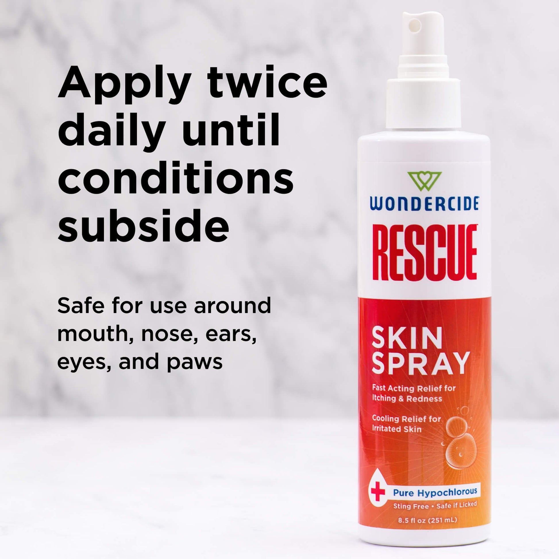 A bottle of Wondercide RESCUE™ Skin Spray for Dogs & Cats rests on a marble surface. Text reads: Apply twice daily until irritation subsides. Safe for use around mouth, nose, ears, eyes, and paws.